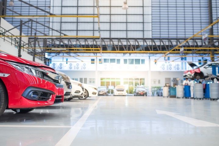 A row of cars are parked in a garage.