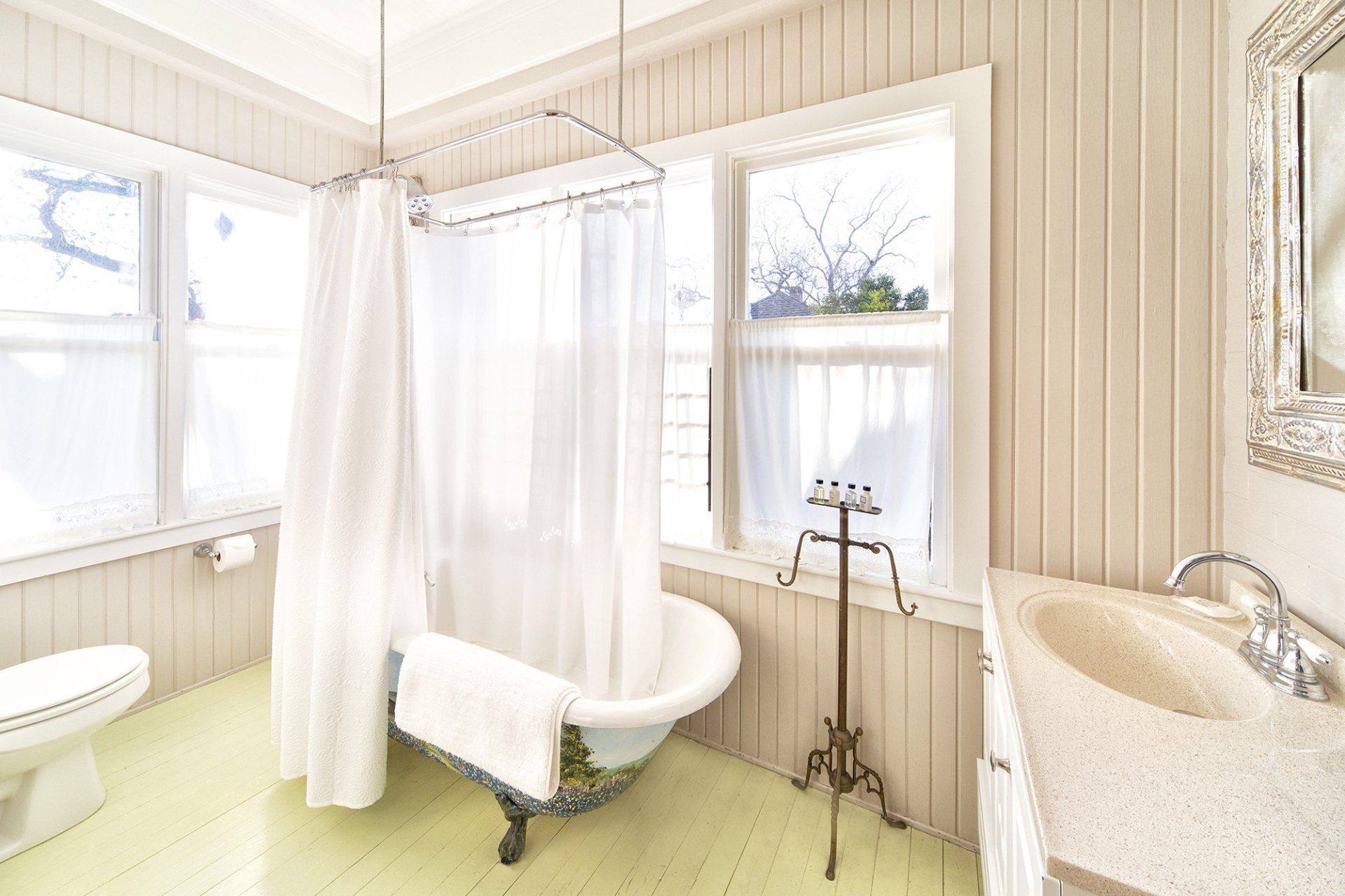 A bathroom with a tub , sink , toilet and window.