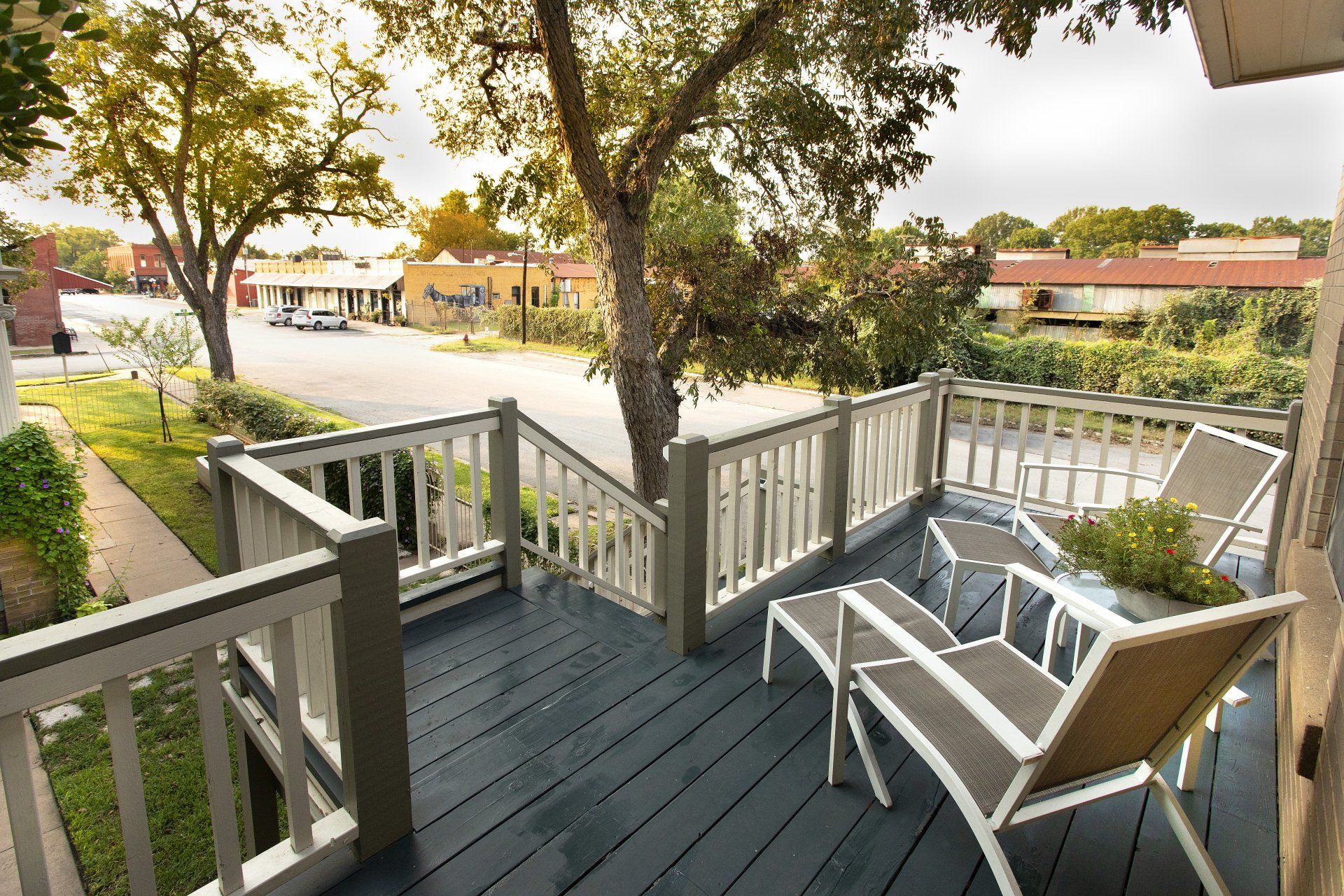 A deck with chairs and a table with a view of a city