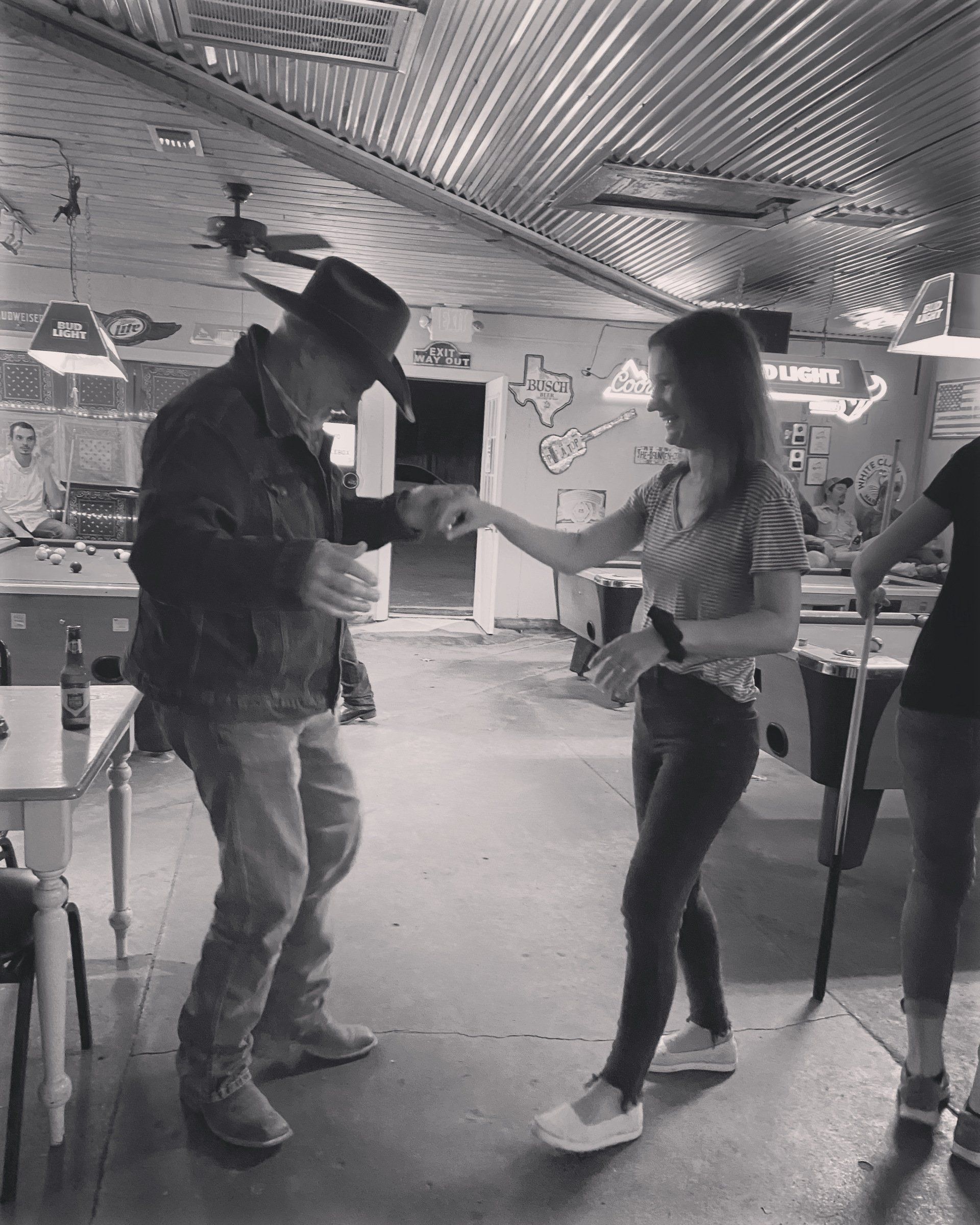 A man and a woman are dancing in a black and white photo.