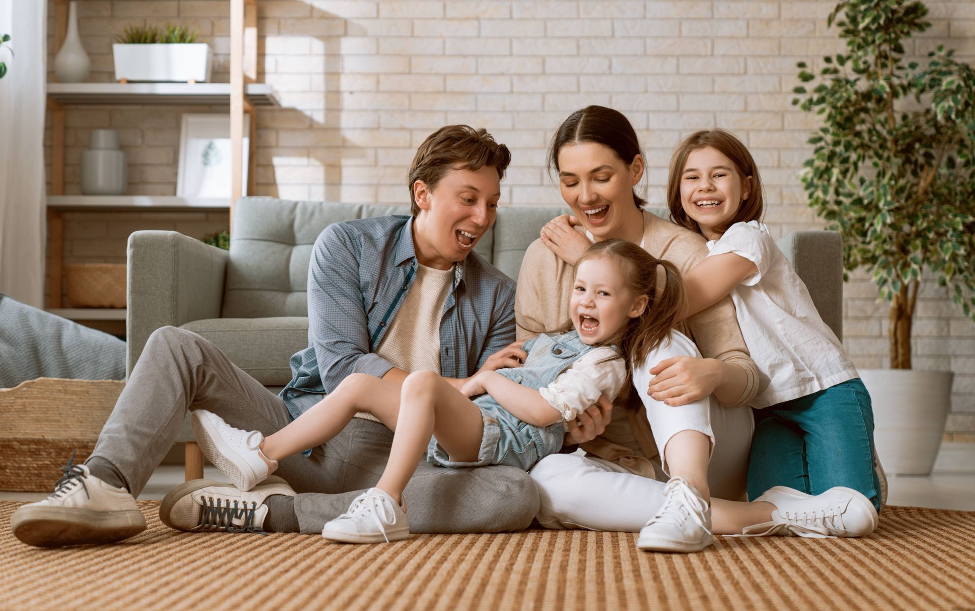a family is sitting on the floor in a living room