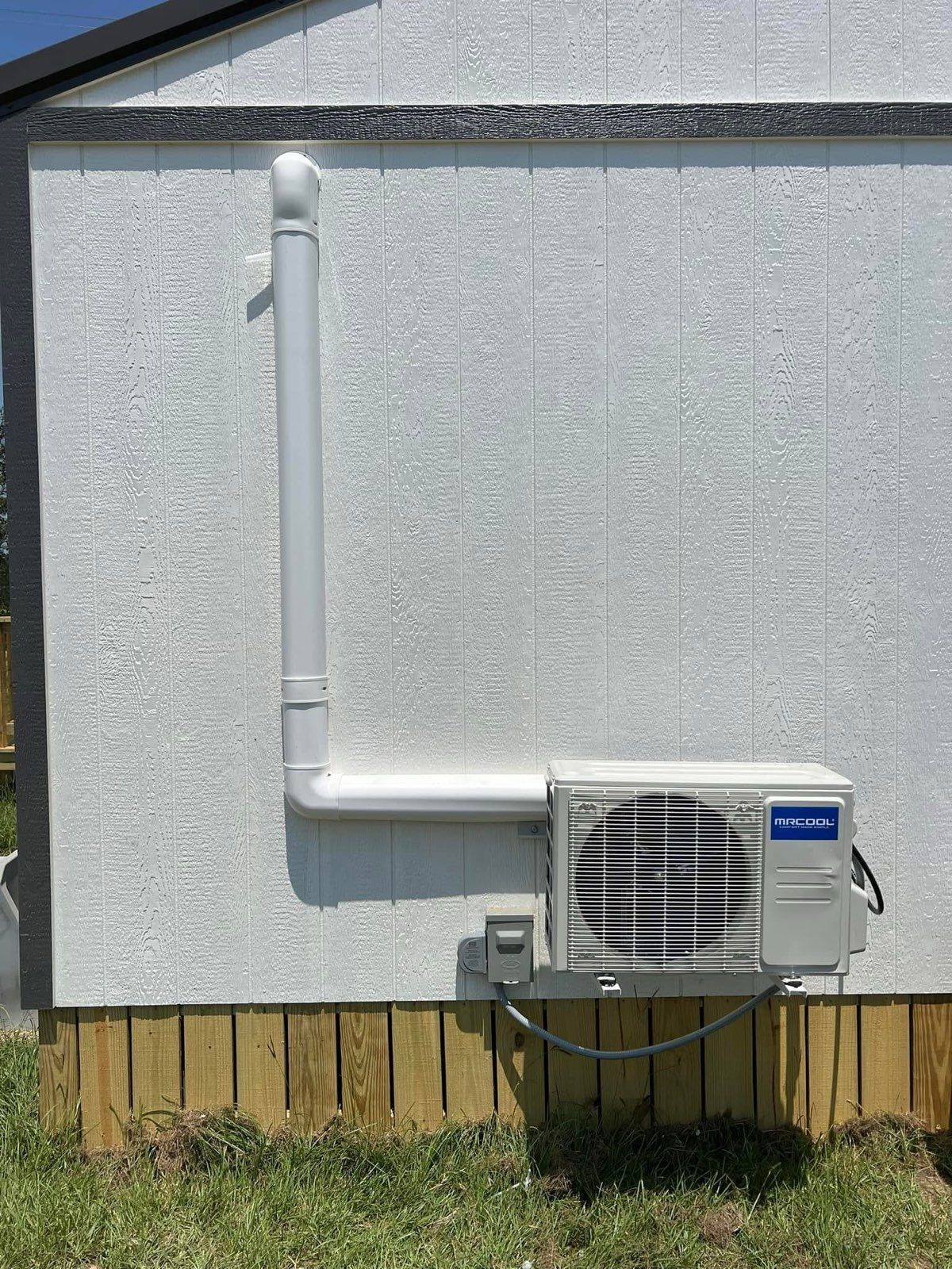 An air conditioner is installed on the side of a house.