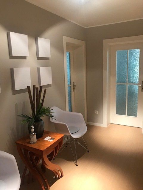 Ein Wartezimmer mit Stuhl und Tisch