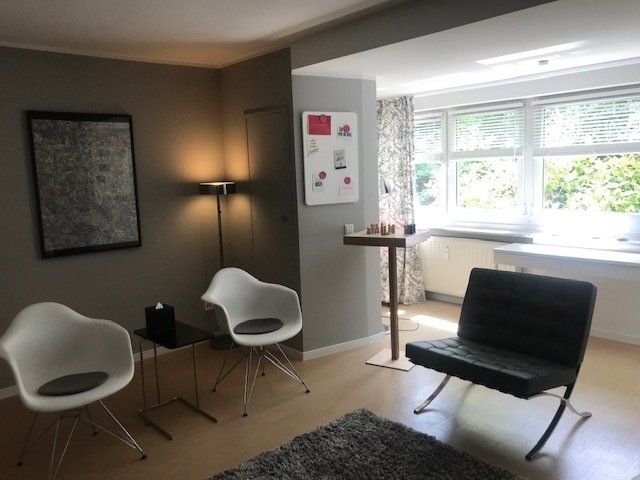 Ein Wohnzimmer mit zwei Stühlen und einem Tisch