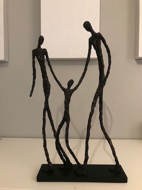 Eine Statue einer Familie, die Händchen hält auf einem Tisch