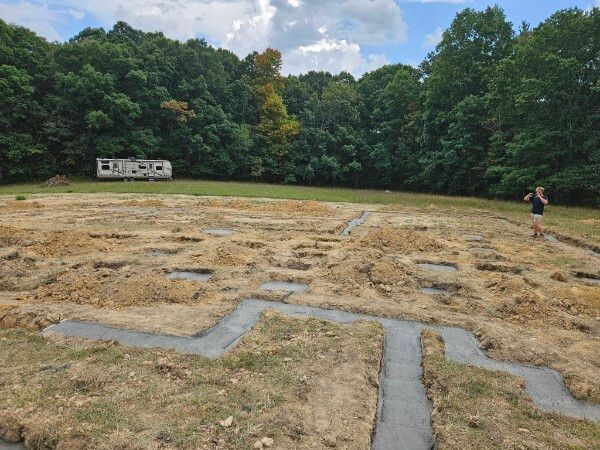 A woman is running through a maze of dirt in a field.