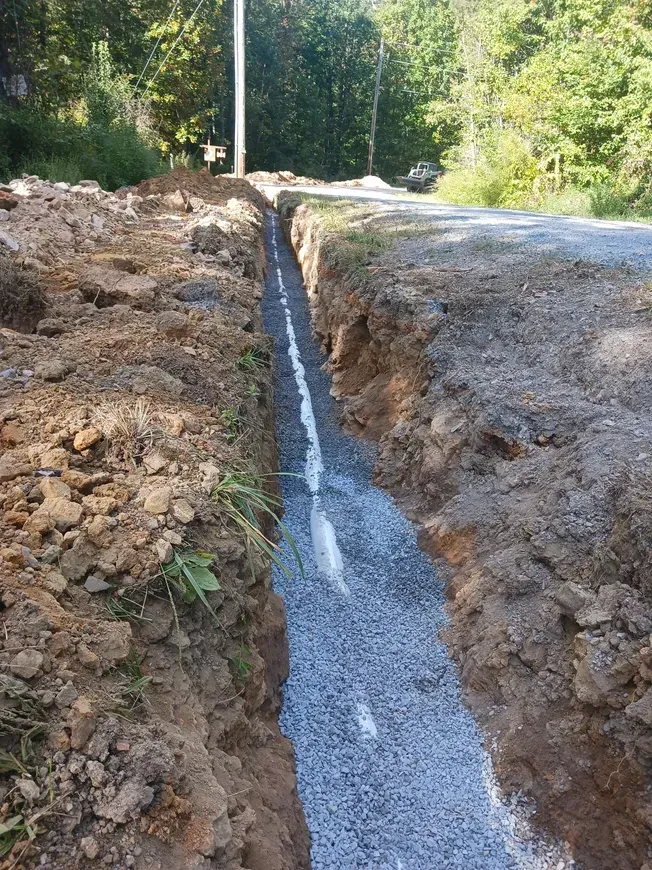 a drain pipe is being installed on the side of a road .