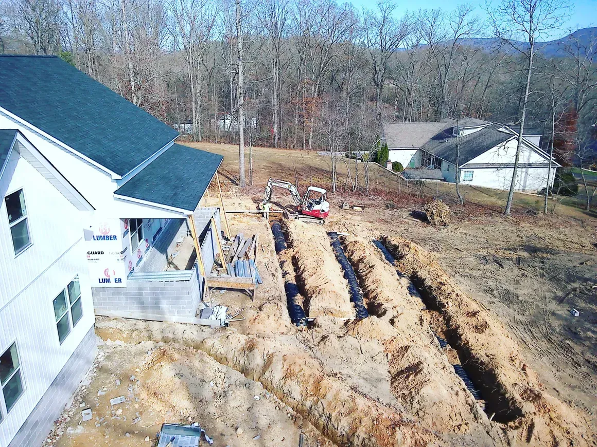an aerial view of a house under construction in the woods .