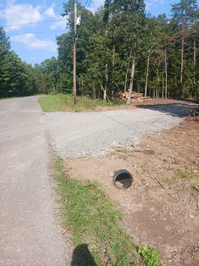 a dirt road with a drain in the middle of it