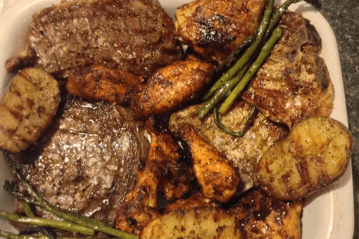 A white plate topped with meat potatoes and asparagus