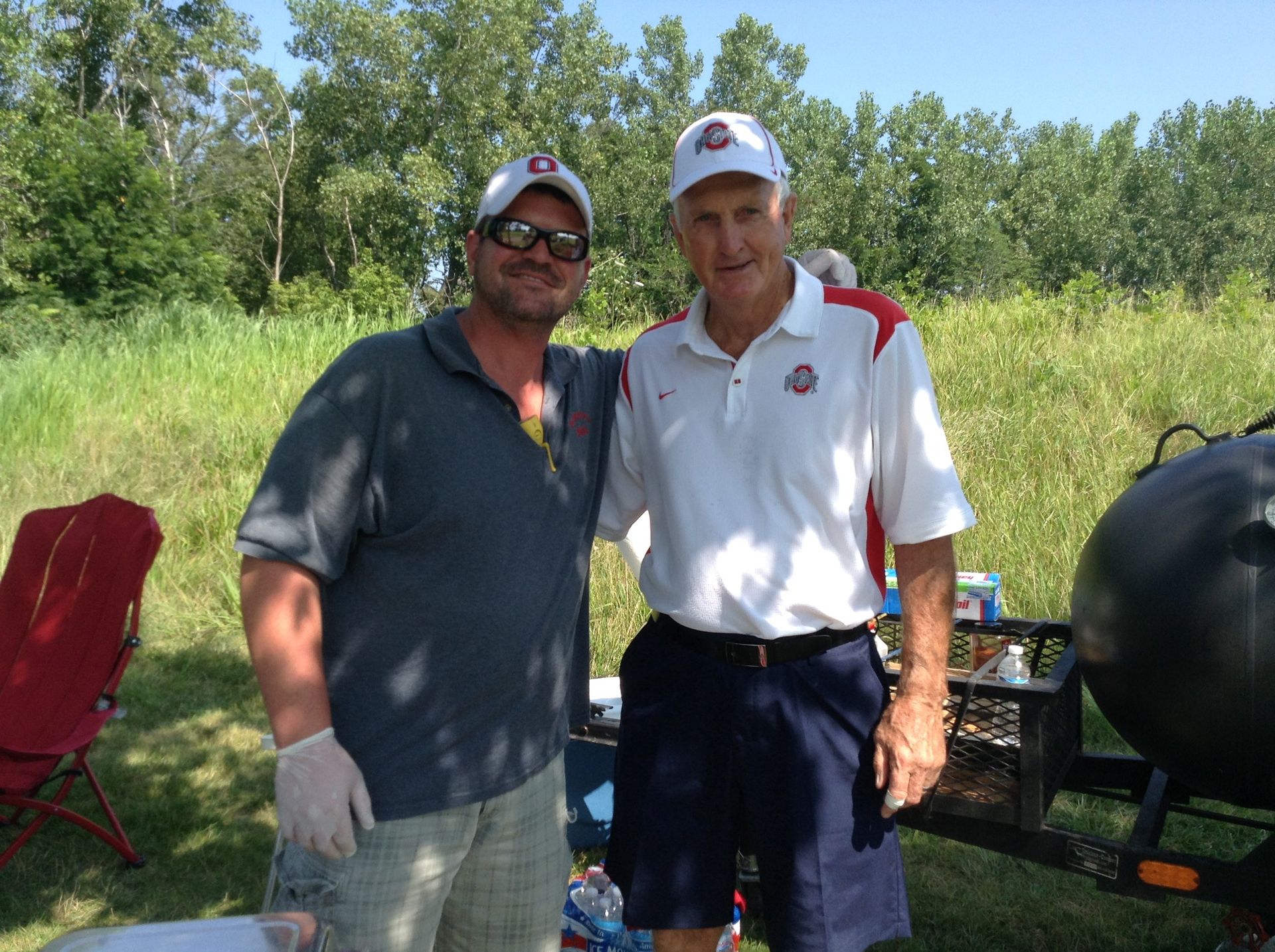 Two men posing for a picture with one wearing a ohio state shirt
