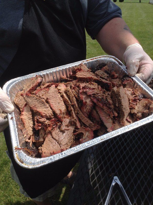 A person is holding a tray of sliced meat