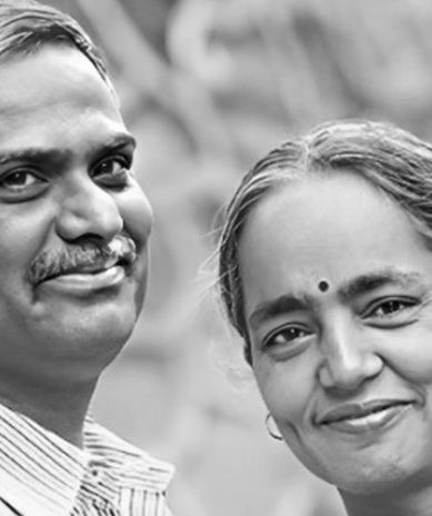 A man and a woman are smiling for the camera in a black and white photo.