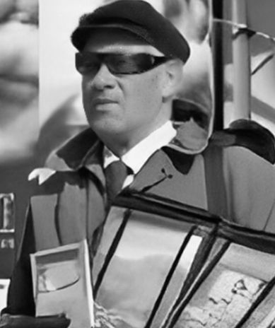 A black and white photo of a man wearing sunglasses and a hat