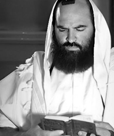 A man with a beard is reading a book in a black and white photo