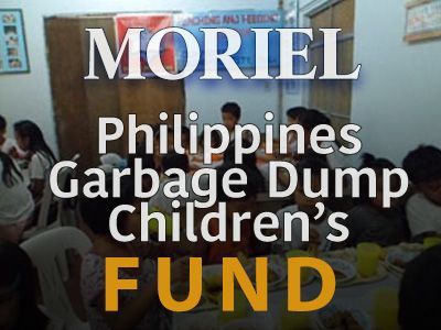 A group of people are sitting around a table with a sign that says moriel philippines garbage dump children 's fund