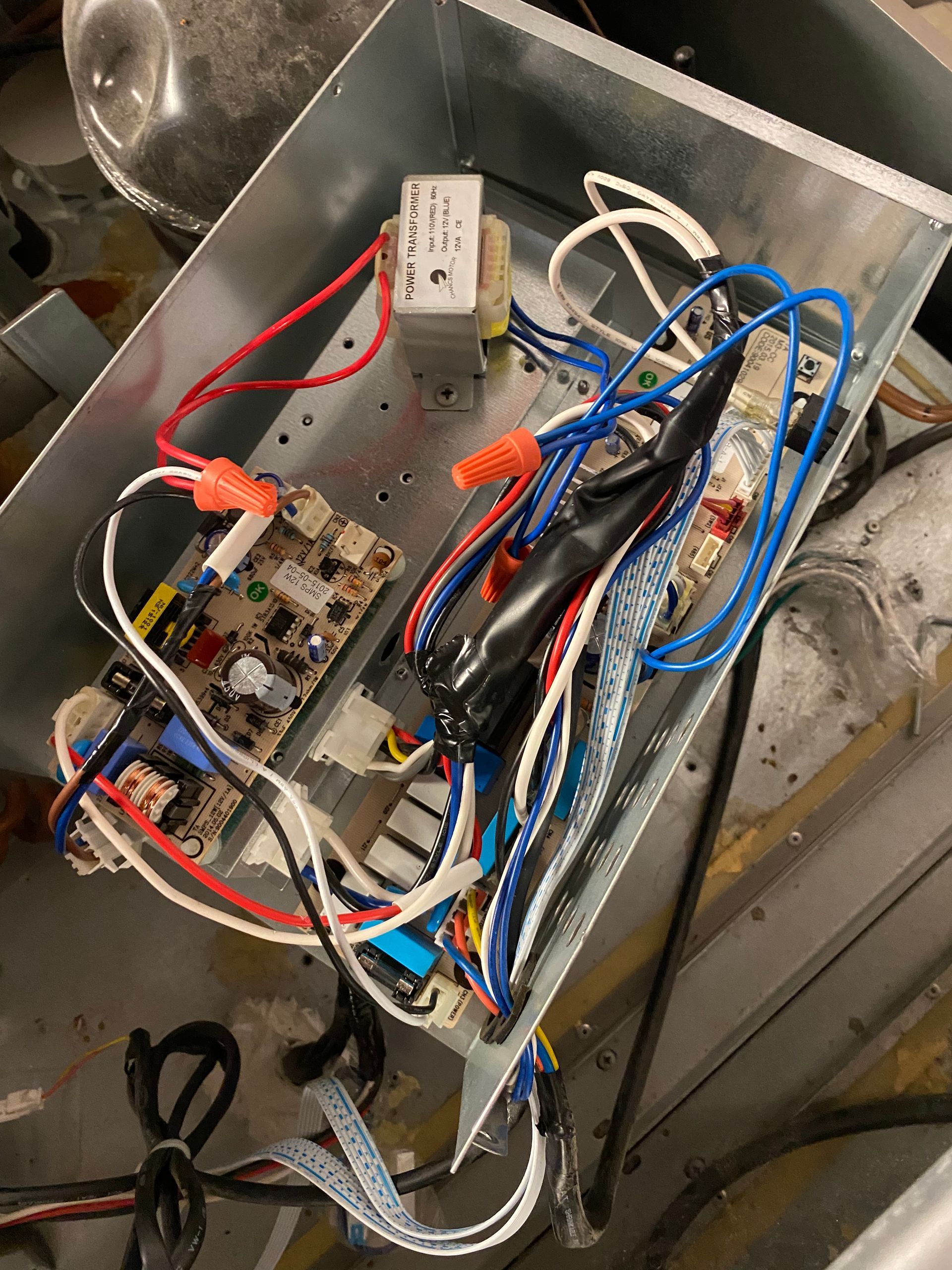 Control panel with wires and circuit boards inside a metal box.