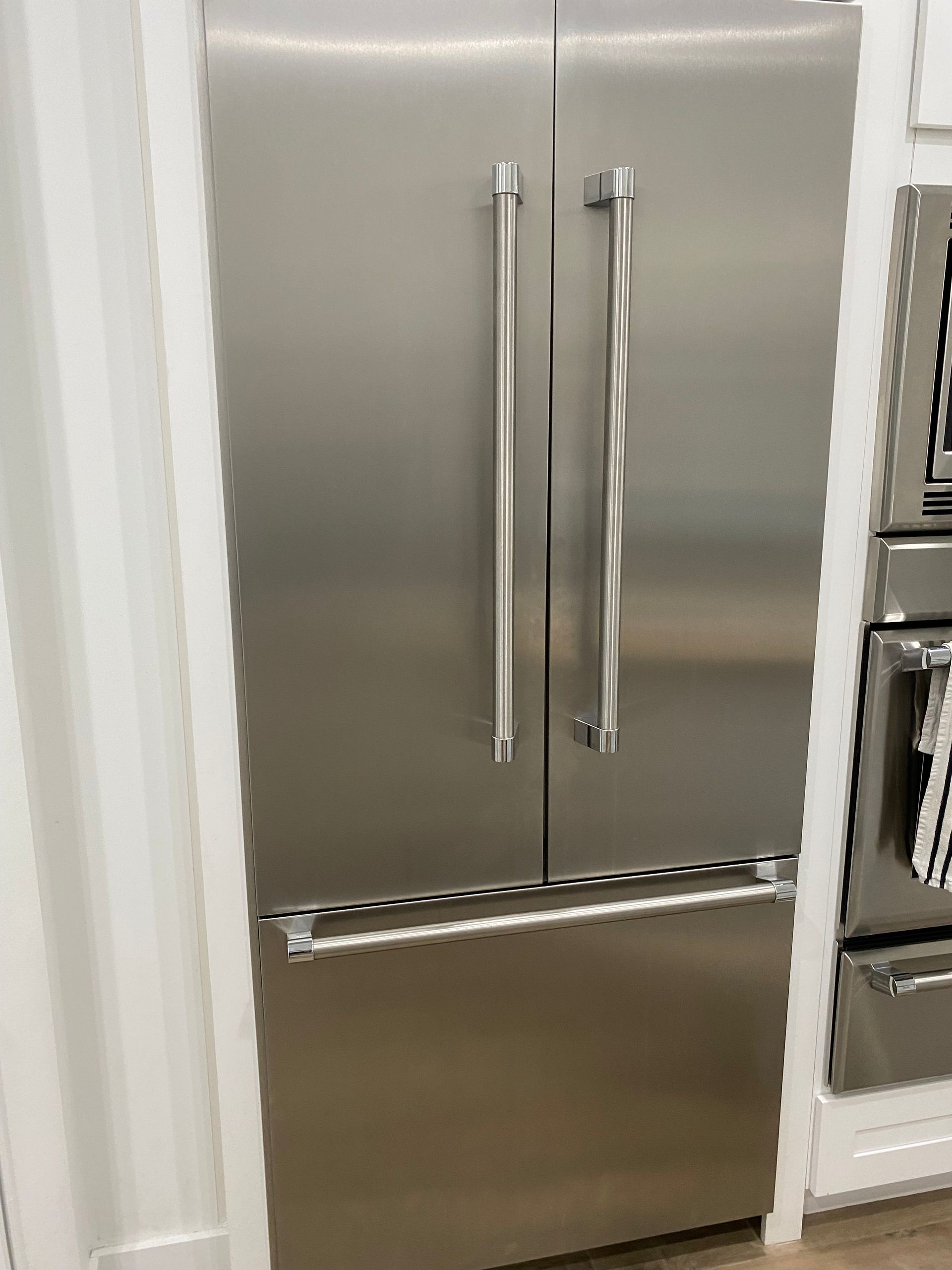 Stainless steel French door refrigerator in a kitchen.