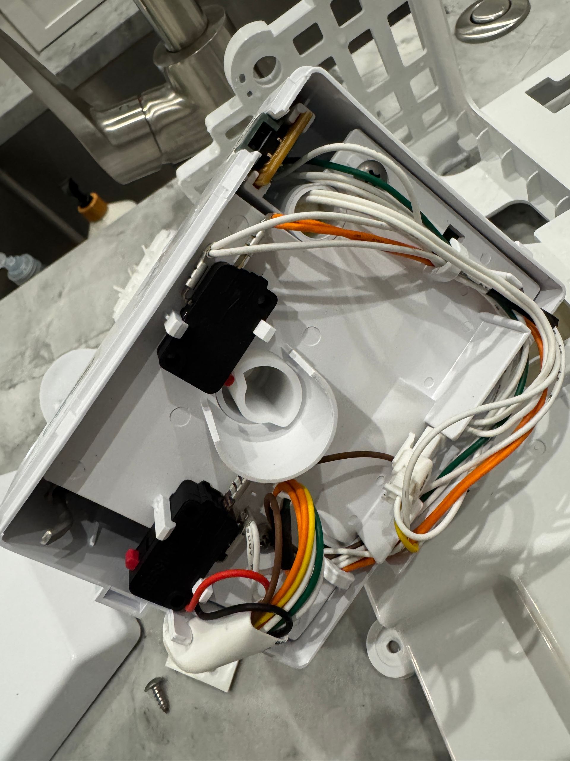 White electrical box with wiring, switches, and a light socket.