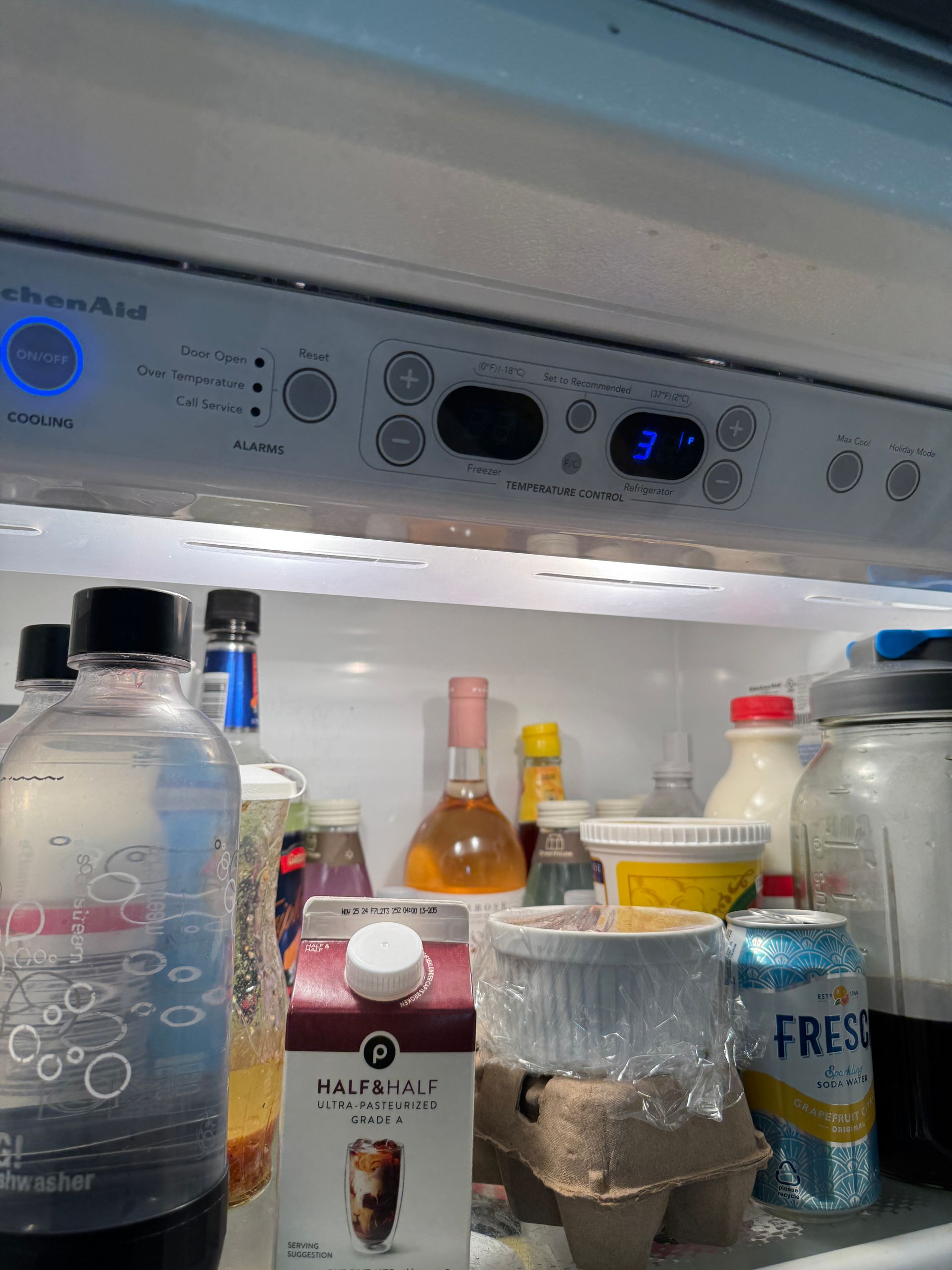 Refrigerator interior with food items, the temperature display shows 3.