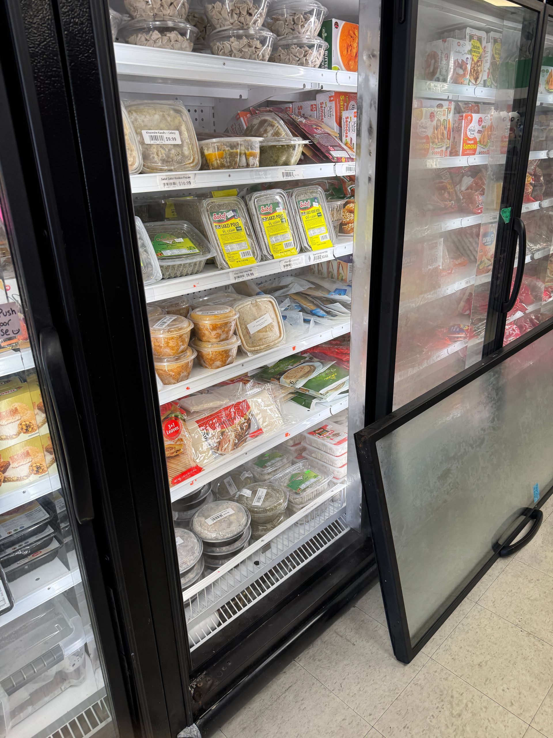 Freezer case displaying various prepared food items in a store.