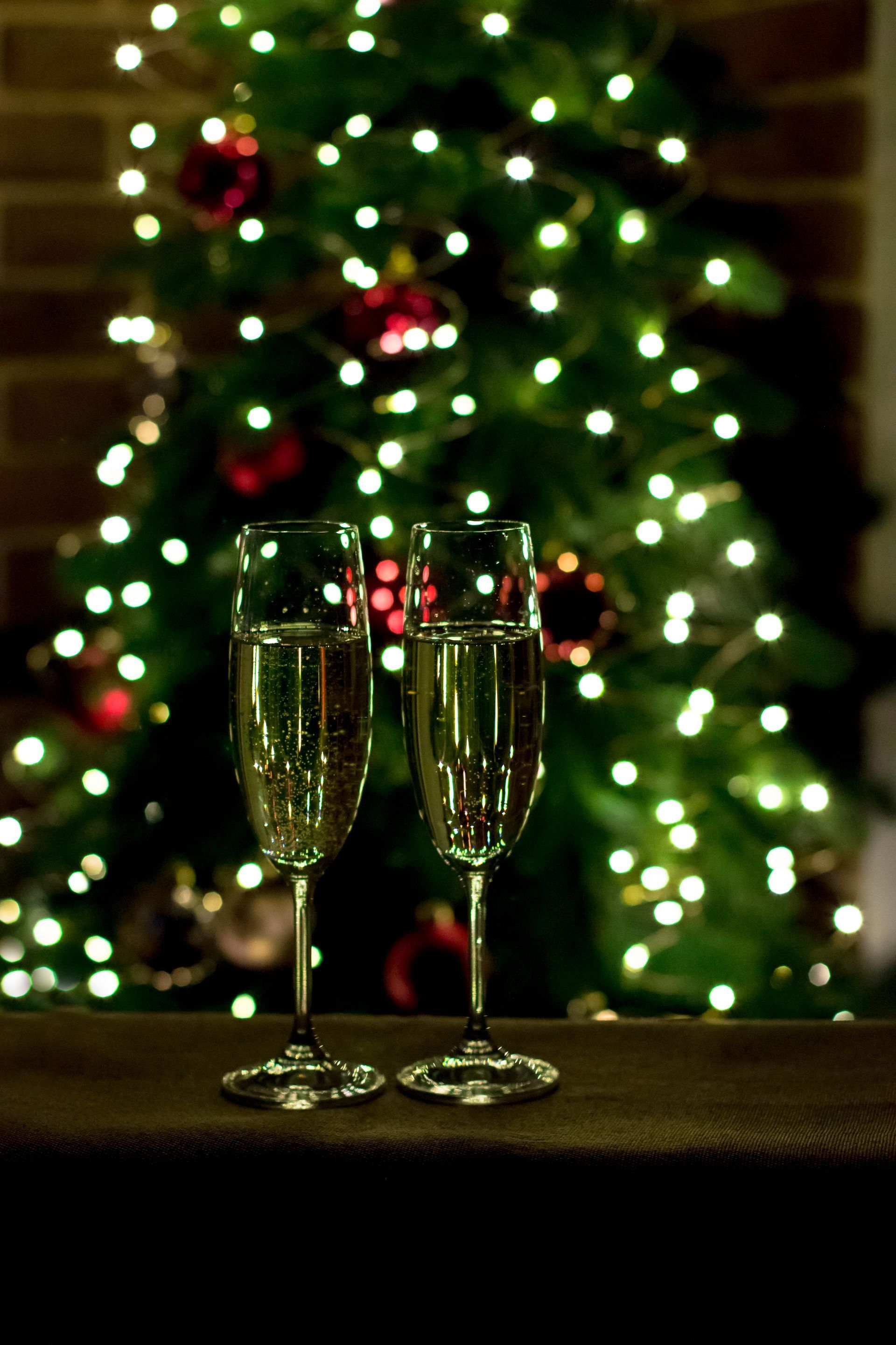 Two glasses of champagne in front of a christmas tree