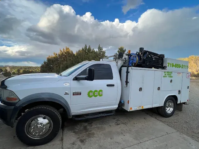 A white truck with the word ccc on the side is parked on the side of the road.