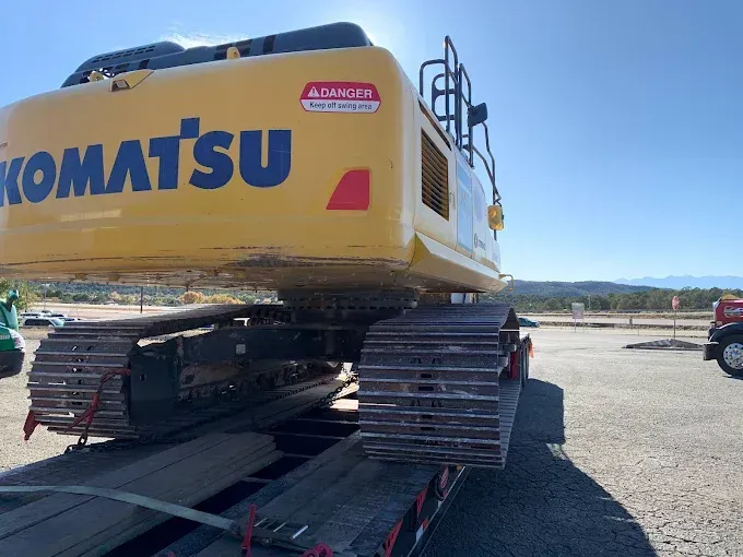 A komatsu excavator is sitting on top of a trailer.