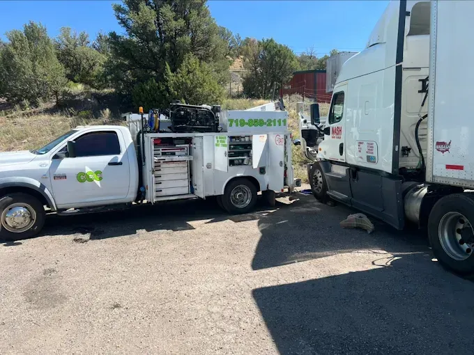 A utility truck is parked next to a semi truck.