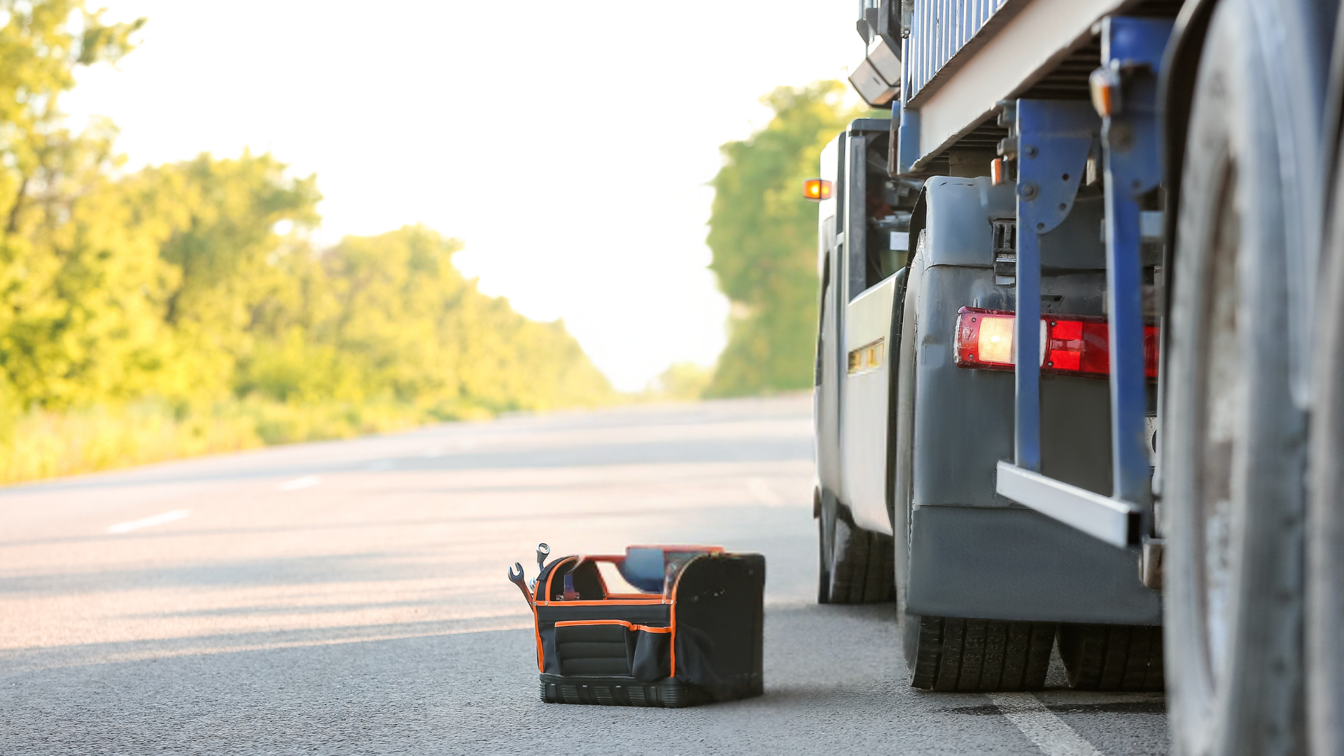 A truck has a flat tire on the side of the road.