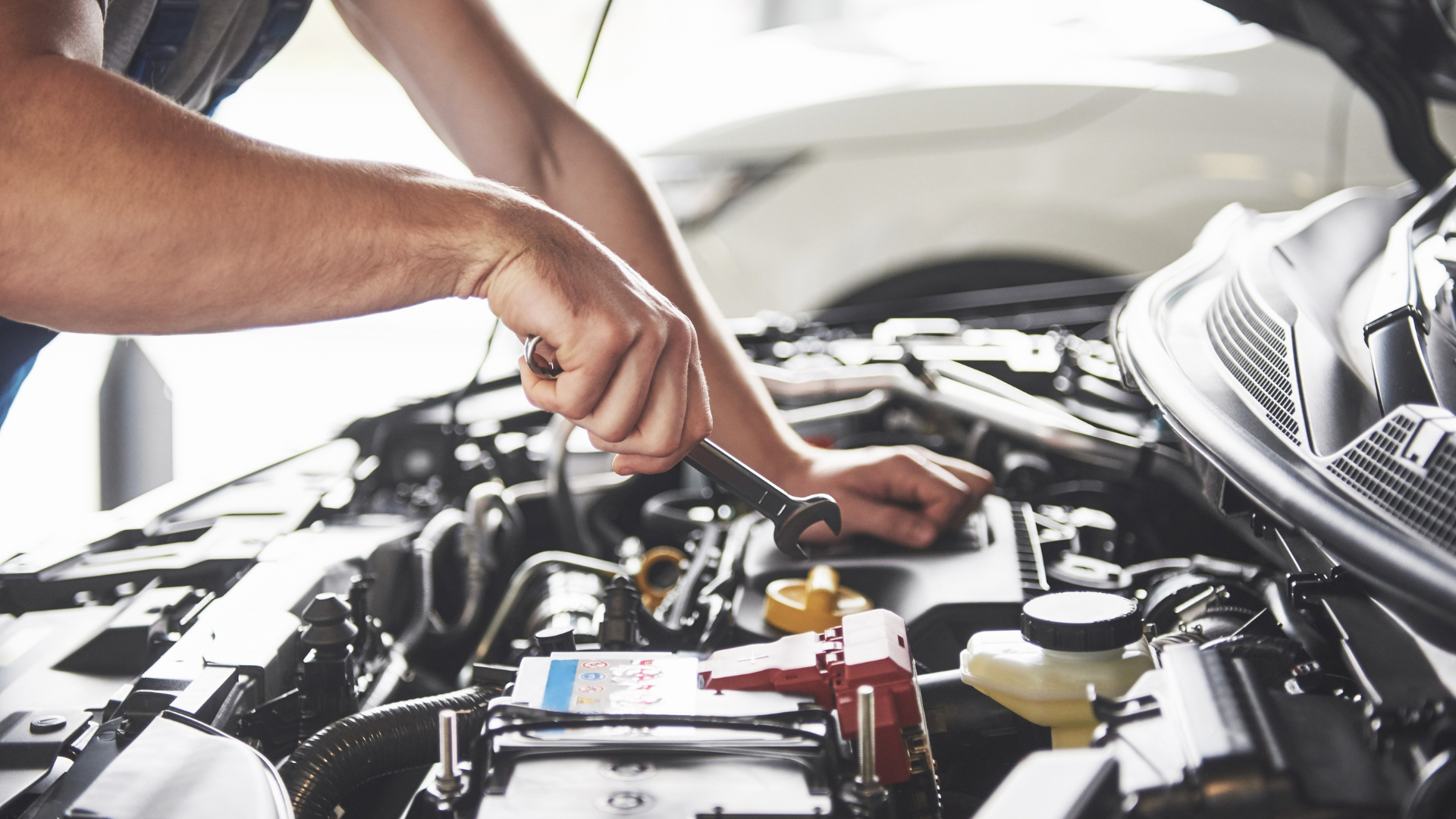 A man is working on the engine of a car.