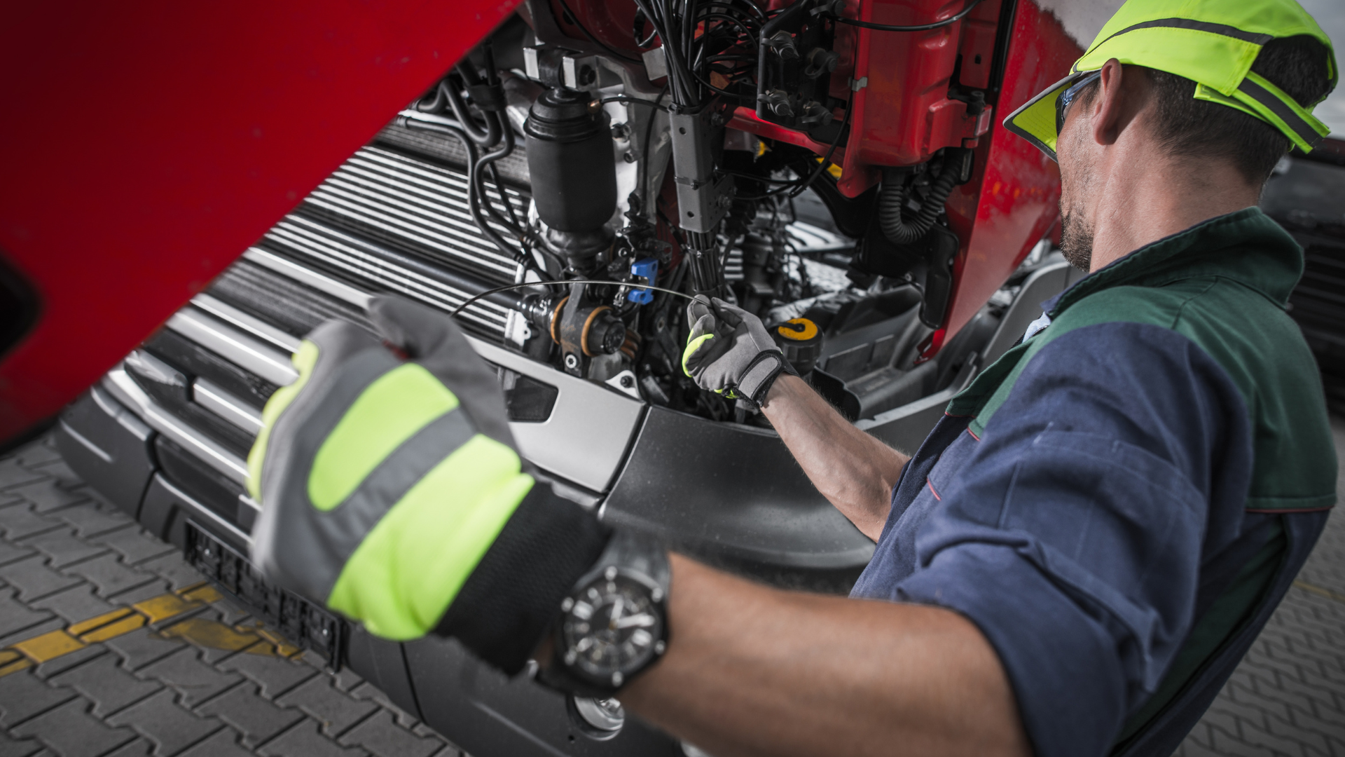 A man is working on the engine of a truck.