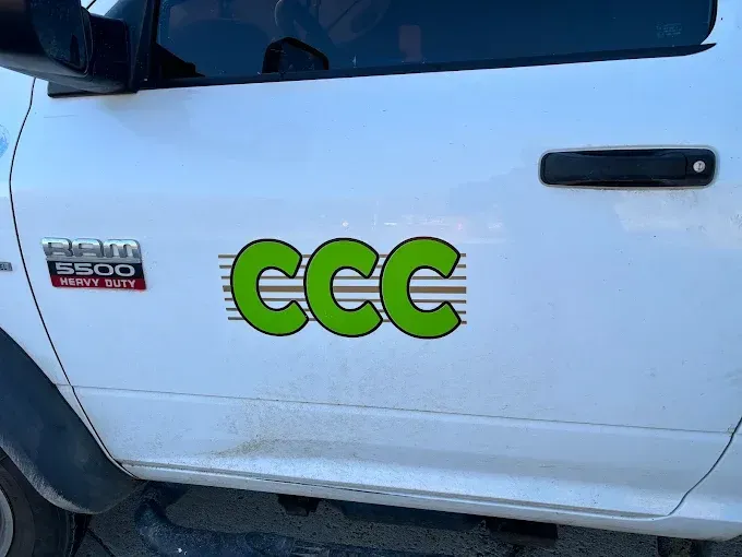 A white truck with a green ccc sticker on the side