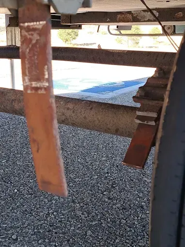 A close up of a piece of wood sitting on top of a gravel road.