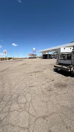 A truck is parked in front of a gas station.