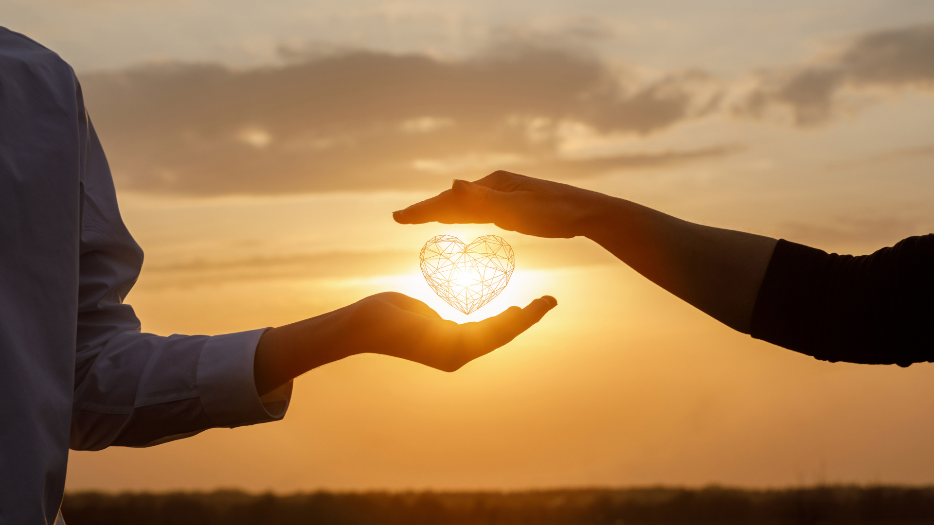 A man and a woman are holding a heart in their hands.