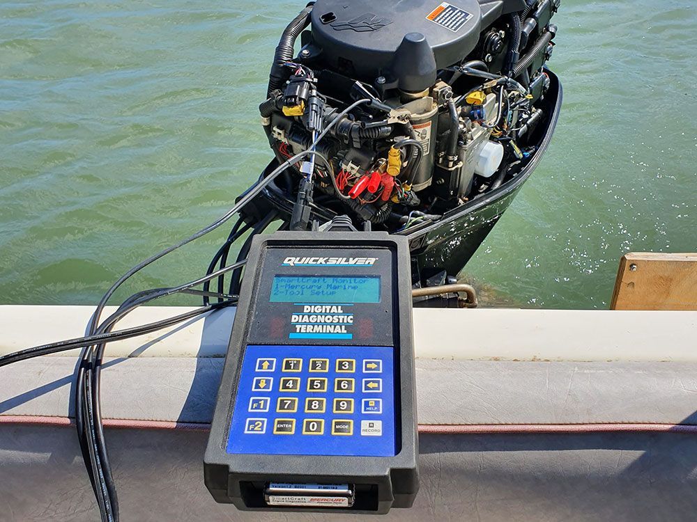 a blue and black device is sitting on a boat next to an outboard motor