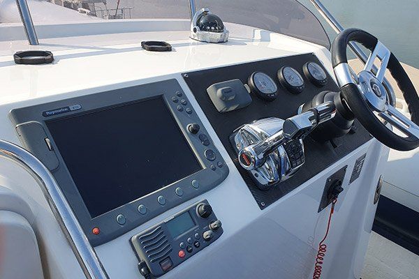 the cockpit of a boat with a monitor and steering wheel