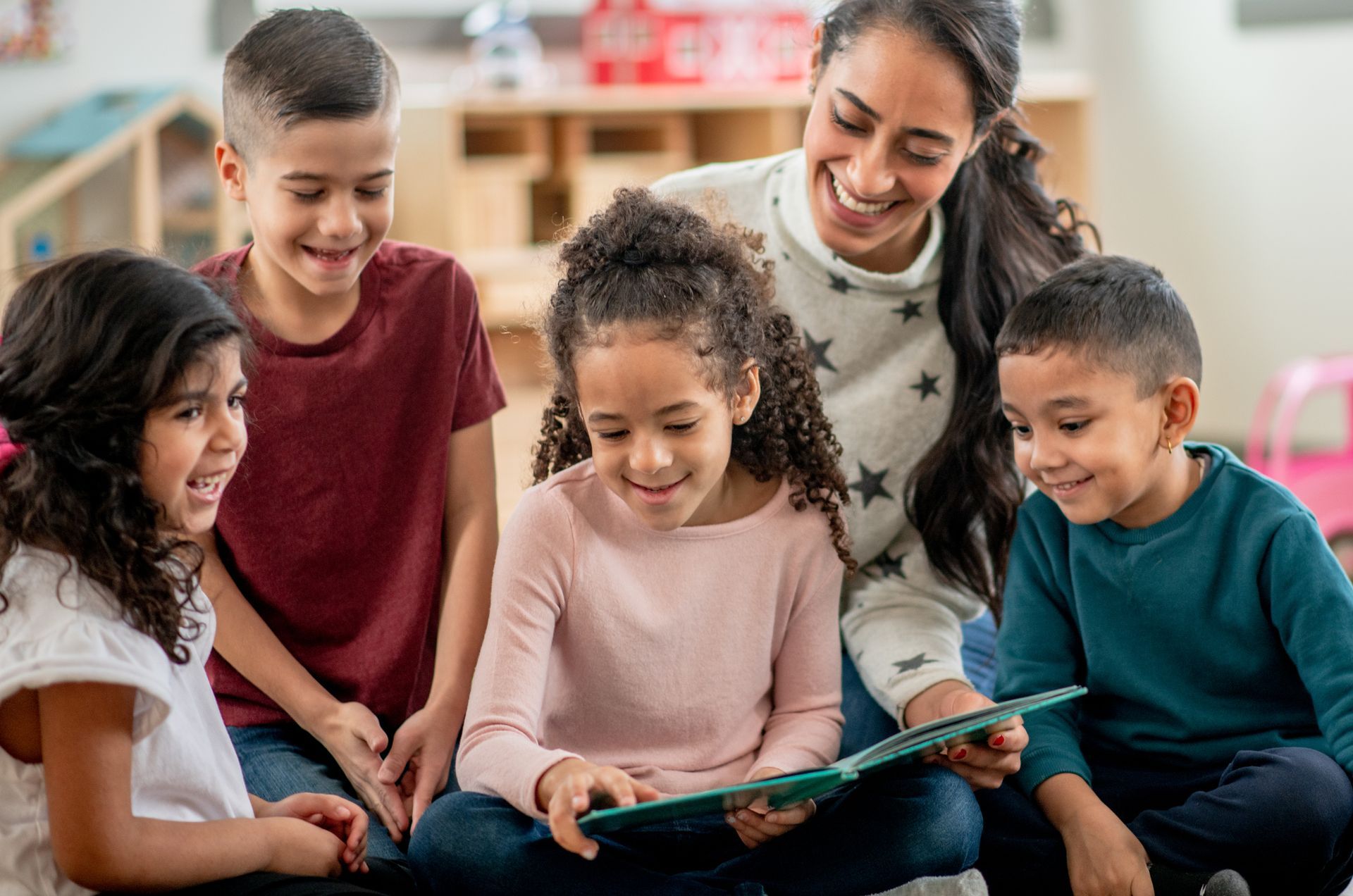 A Teacher Is Reading a Book to A Group of Children.