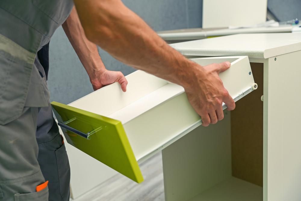 A Man Is Taking a Drawer Out Of a Cabinet — Smith's Joinery in Kyogle, NSW