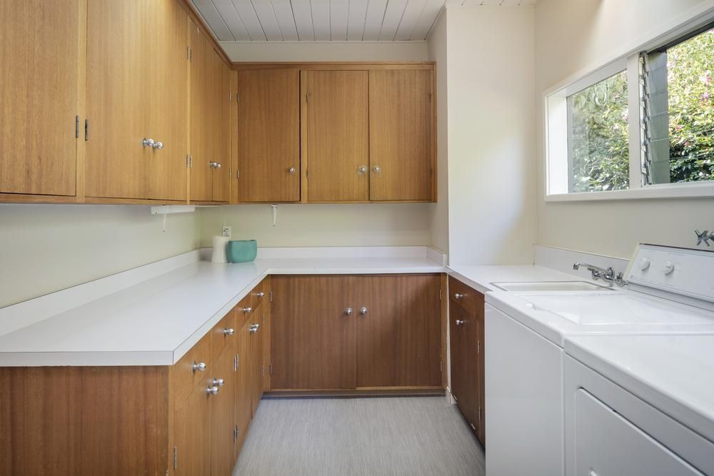 A Laundry Room with A Washer and Dryer and Wooden Cabinets — Smith's Joinery in Tenterfield, NSW