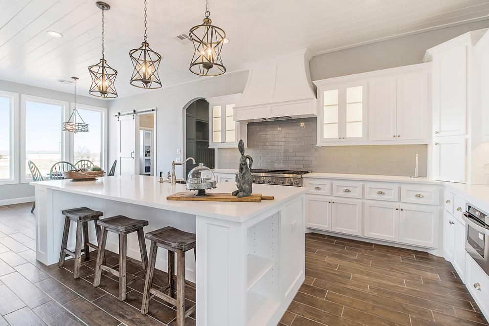 A Kitchen with White Cabinets and Stools and A Large Island — Smith's Joinery in Ballina, NSW