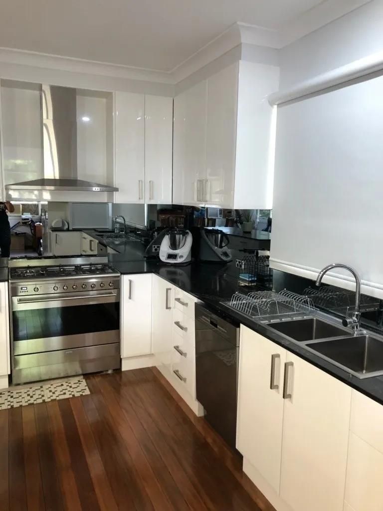 A Kitchen with Stainless Steel Appliances and White Cabinets — Smith's Joinery in Ballina, NSW