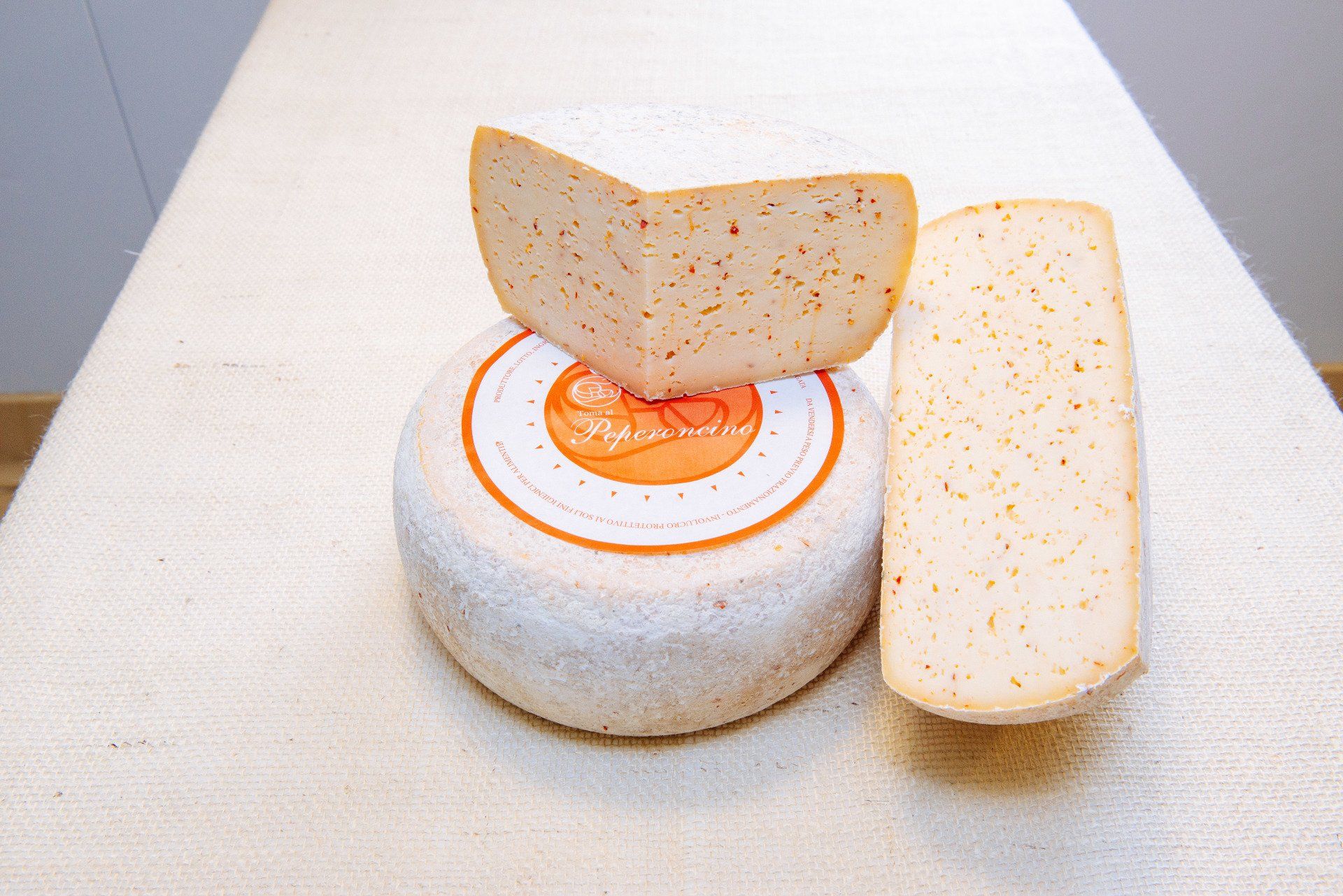 Un pezzo di formaggio è appoggiato sopra una forma di formaggio