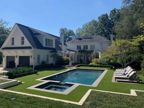 A large house with a large swimming pool in front of it