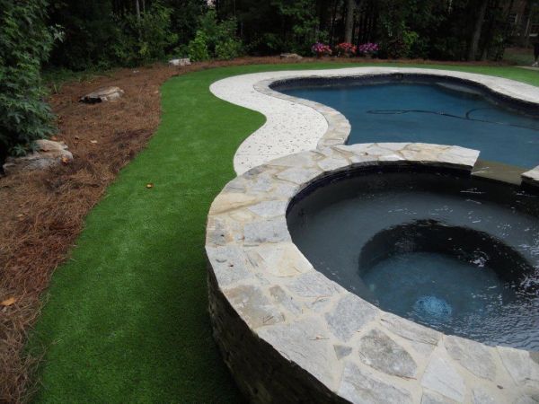 A large swimming pool with a hot tub in the middle of it.