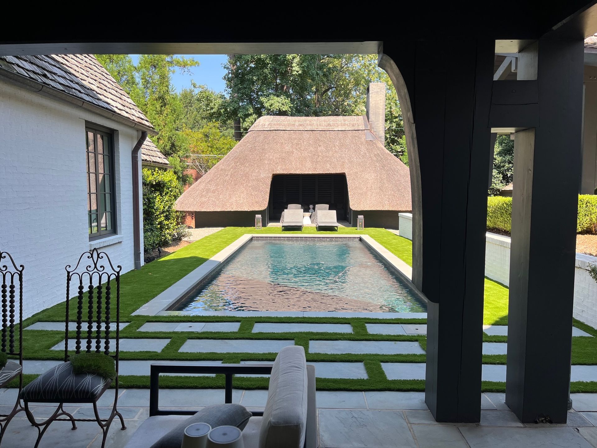 A large swimming pool is in the backyard of a house