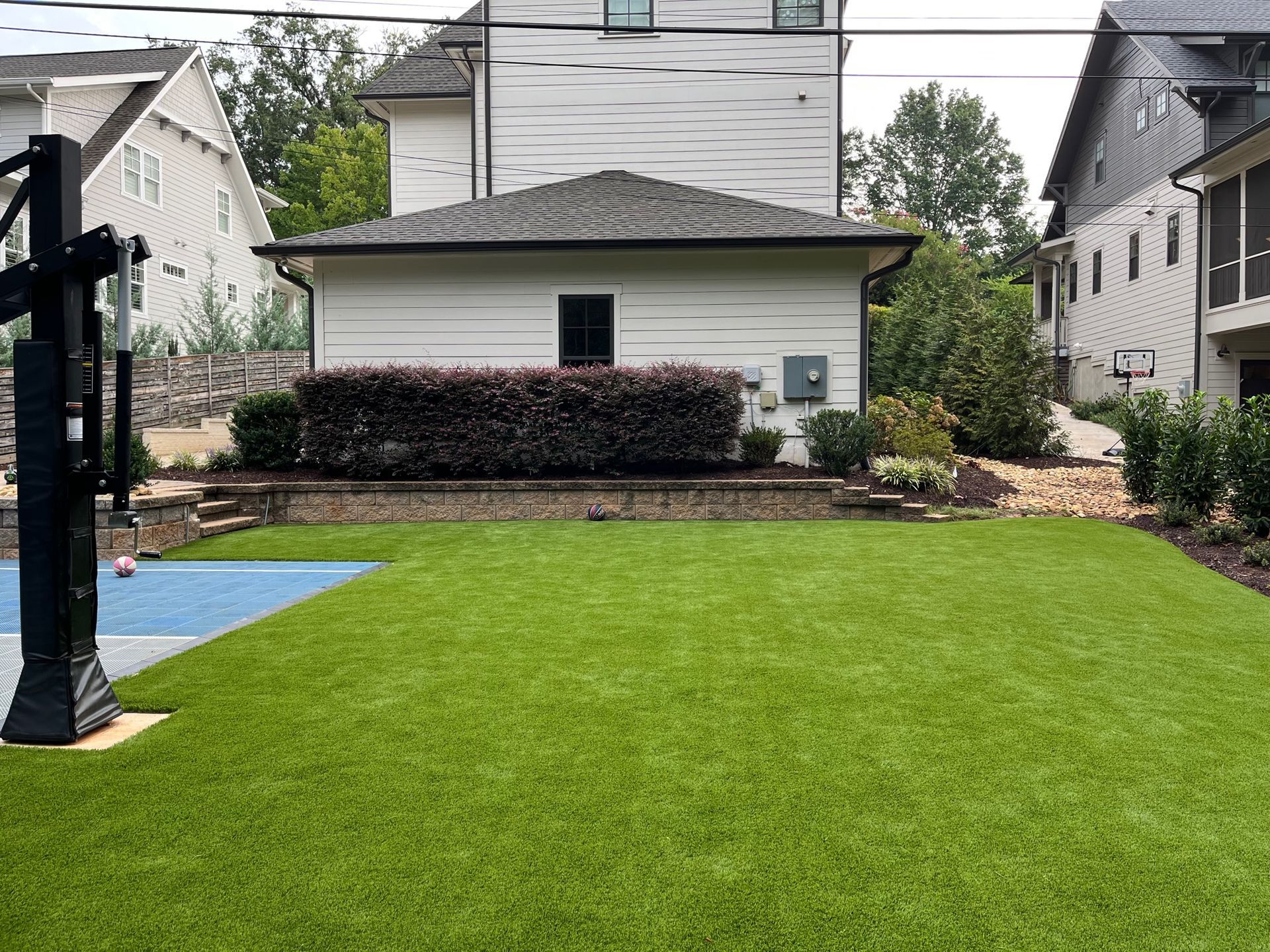 There is a basketball hoop in the backyard of a house.