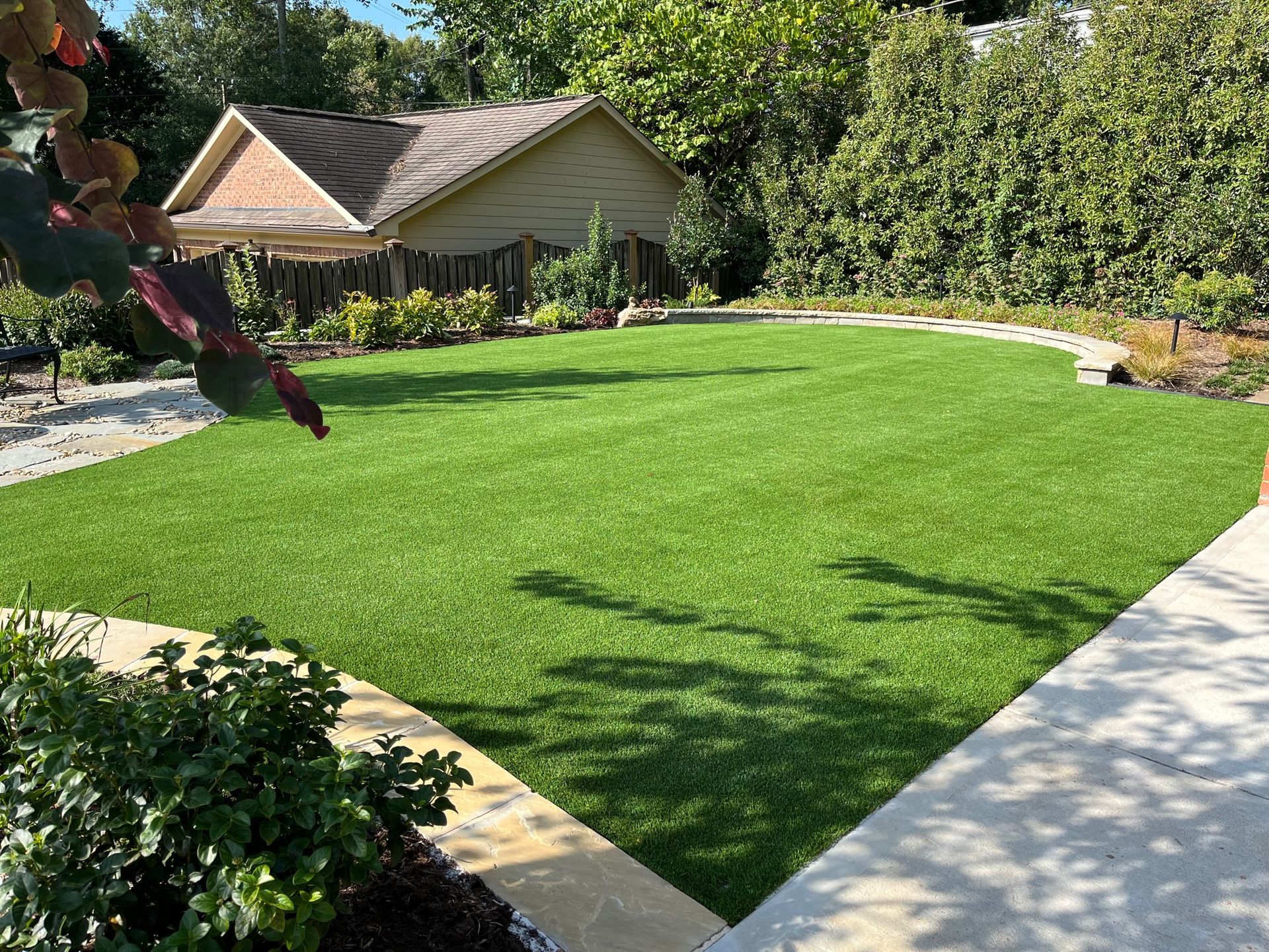 A large lush green lawn with a house in the background.