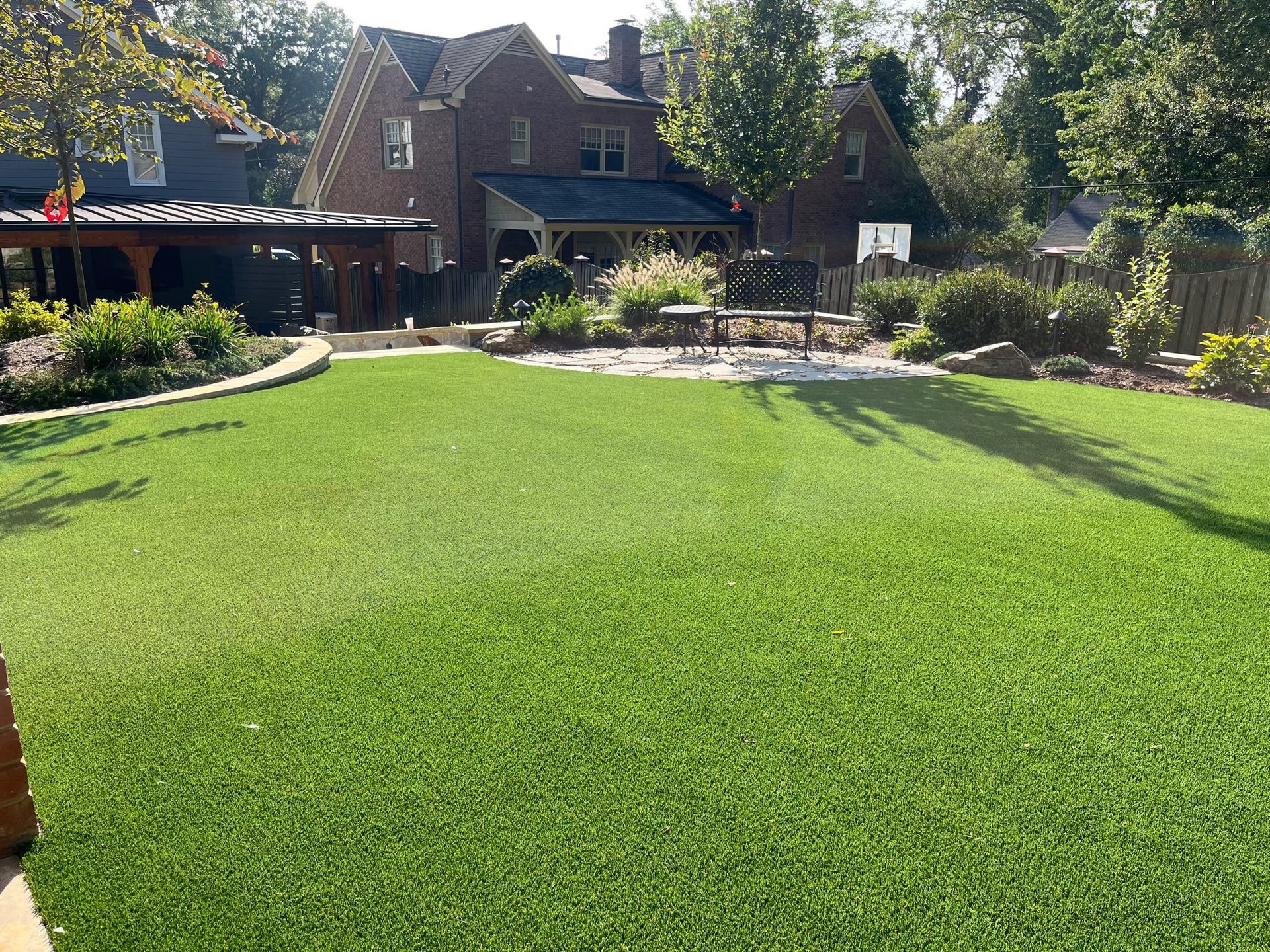 A large lush green lawn in front of a brick house.